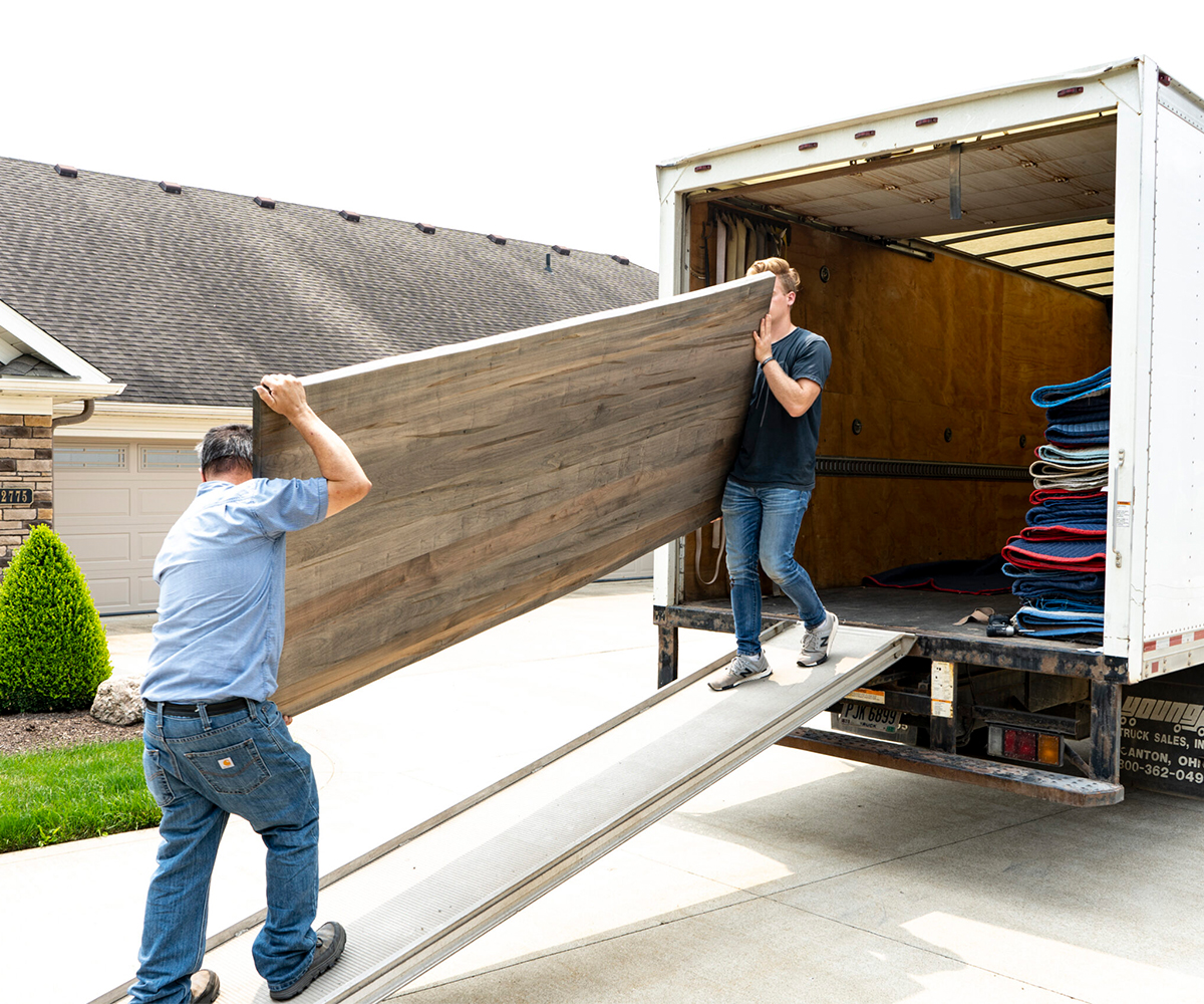 Amish Furniture in Greeneville delivery team unloading solid wood tabletop from truck.